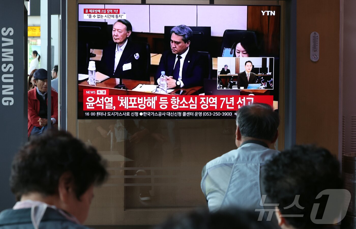 본문 이미지 - 29일 오후 서울시 용산구 한강대로 서울역 대합실에서 시민들이 특수공무집행방해, 직권남용 권리행사방해, 허위 공문서 작성 등의 혐의를 받는 윤석열 전 대통령의 항소심 선고 공판 생중계를 지켜보고 있다. 윤 전 대통령은 지난 1심 징역 5년 보다 2년 높은 징역 7년형을 선고 받았다. 2026.4.29 ⓒ 뉴스1 김진환 기자