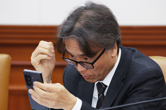 휴대폰 바라보는 금한승 차관