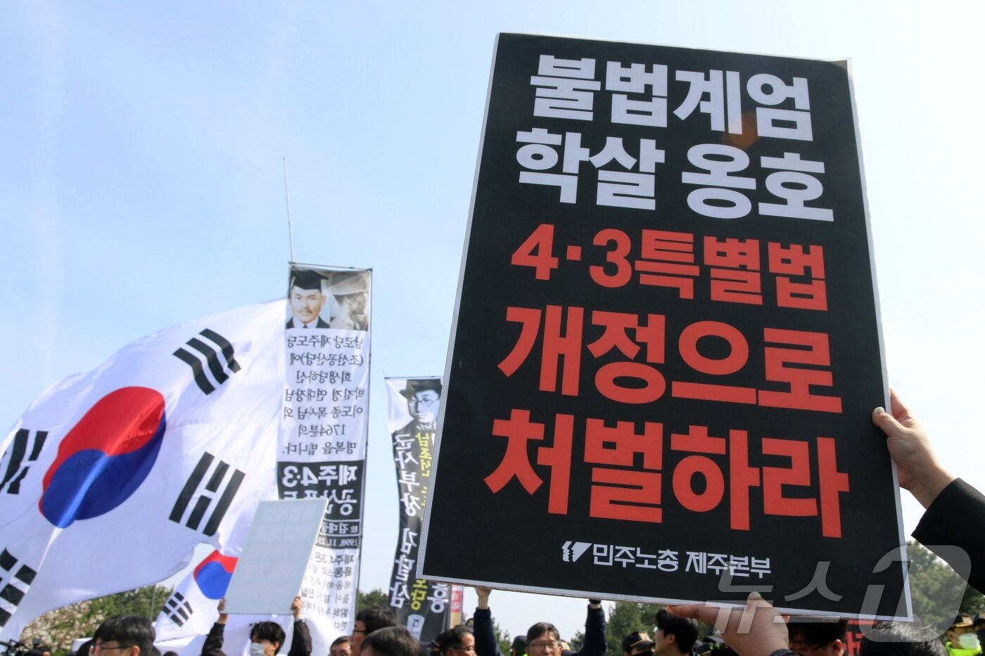 본문 이미지 - 78주년 제주4·3희생자 추념식이 열리고 있는 3일 오전 제주시 봉개동 제주4·3평화공원 인근에서 민주노총 관계자들이 '불법 계엄 학살 옹호 4·3특별법 개정으로 처벌하라'는 팻말을 들고 있다. 이날 이곳에서는 추념식과 동시에 일부 극우단체 50여 명이 집회 신고를 했다.2026.4.3 ⓒ 뉴스1 홍수영 기자
