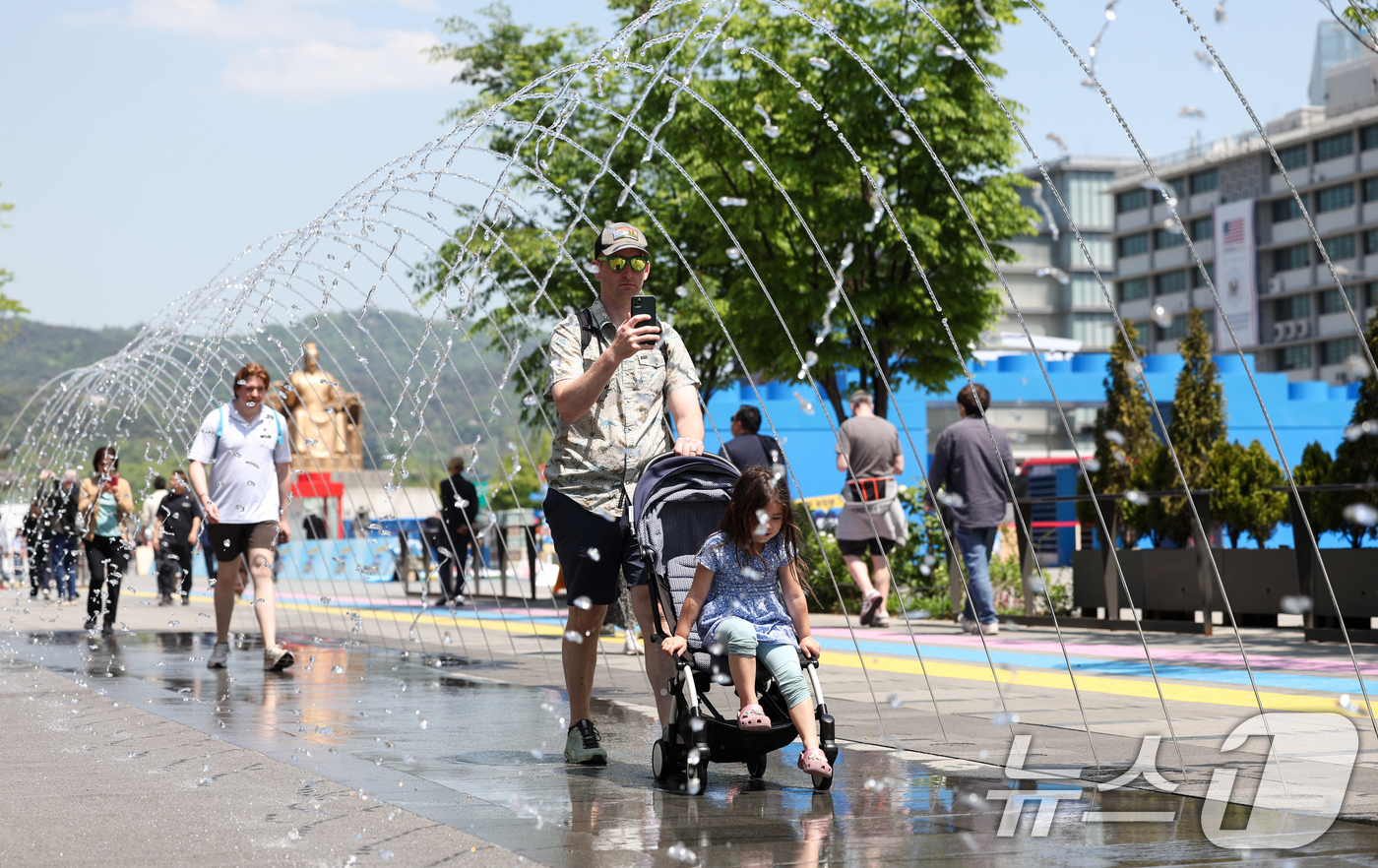 (서울=뉴스1) 임지훈 인턴기자 = 서울 낮 최고 기온이 22도까지 오르는 등 따듯한 봄 날씨를 보인 30일 서울 종로구 광화문광장을 찾은 외국인 관광객들이 분수 터널을 지나가고 …
