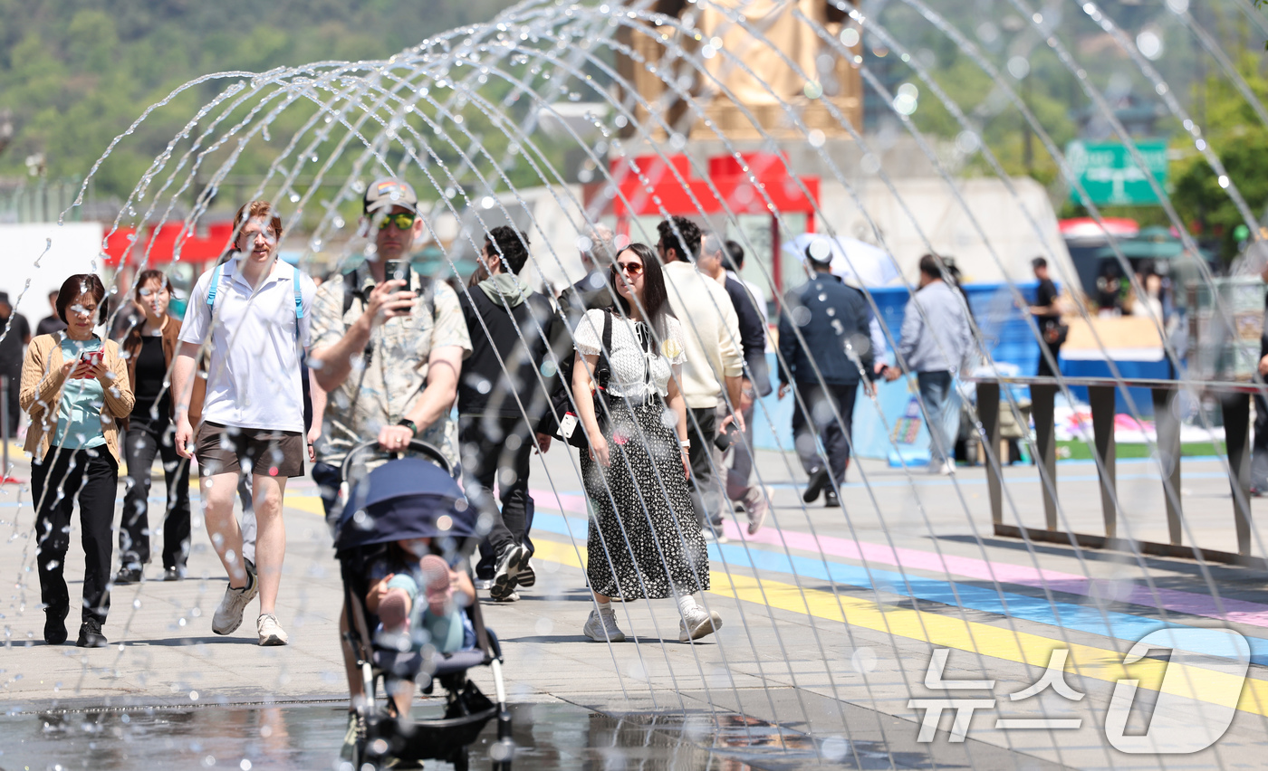 (서울=뉴스1) 임지훈 인턴기자 = 서울 낮 최고 기온이 22도까지 오르는 등 따듯한 봄 날씨를 보인 30일 서울 종로구 광화문광장을 찾은 외국인 관광객들이 분수 터널을 지나가고 …