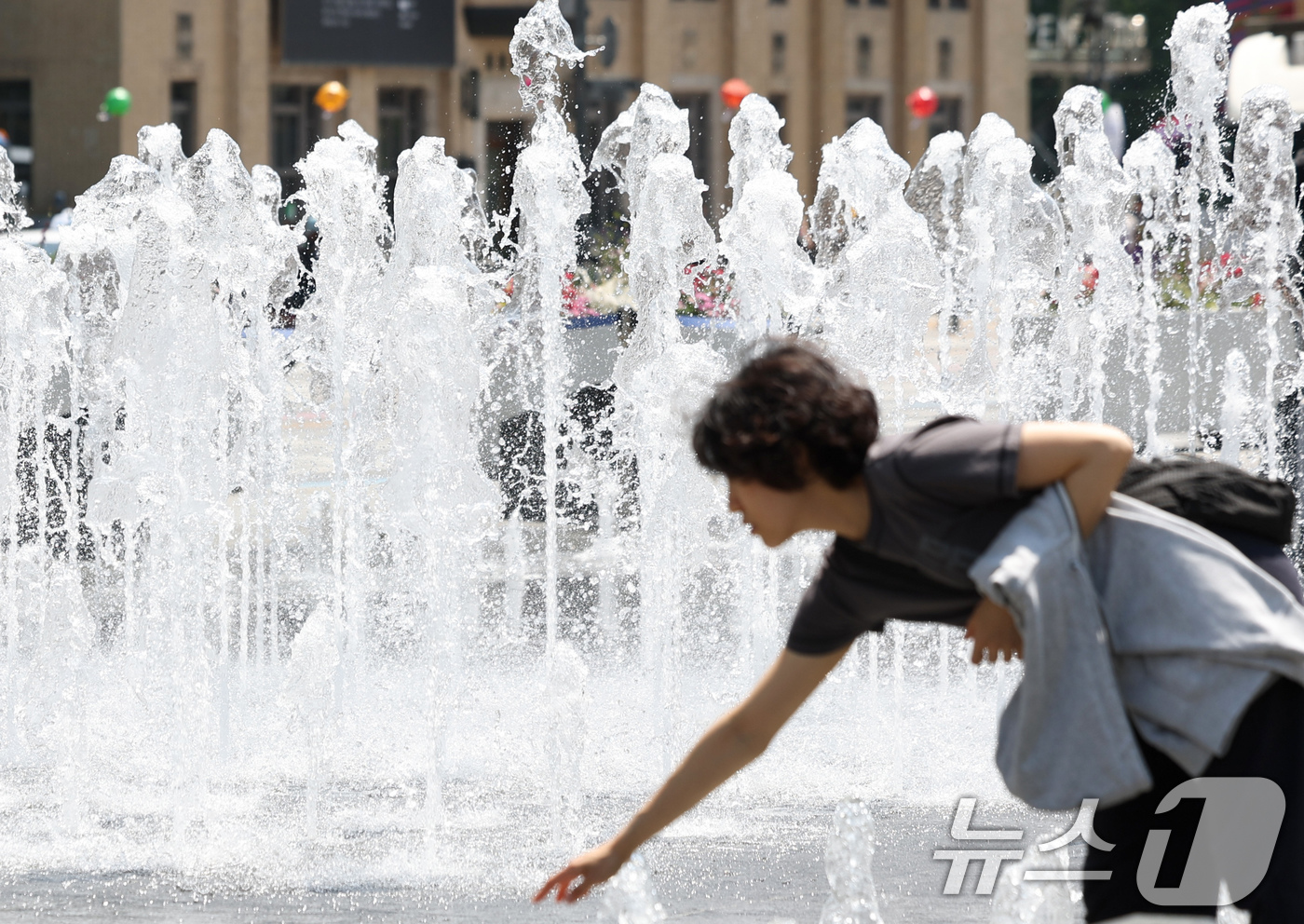 (서울=뉴스1) 임지훈 인턴기자 = 서울 낮 최고 기온이 22도까지 오르는 등 초여름 날씨를 보인 30일 서울 종로구 광화문광장 바닥분수를 찾은 한 시민이 물에 손을 적시며 더위를 …