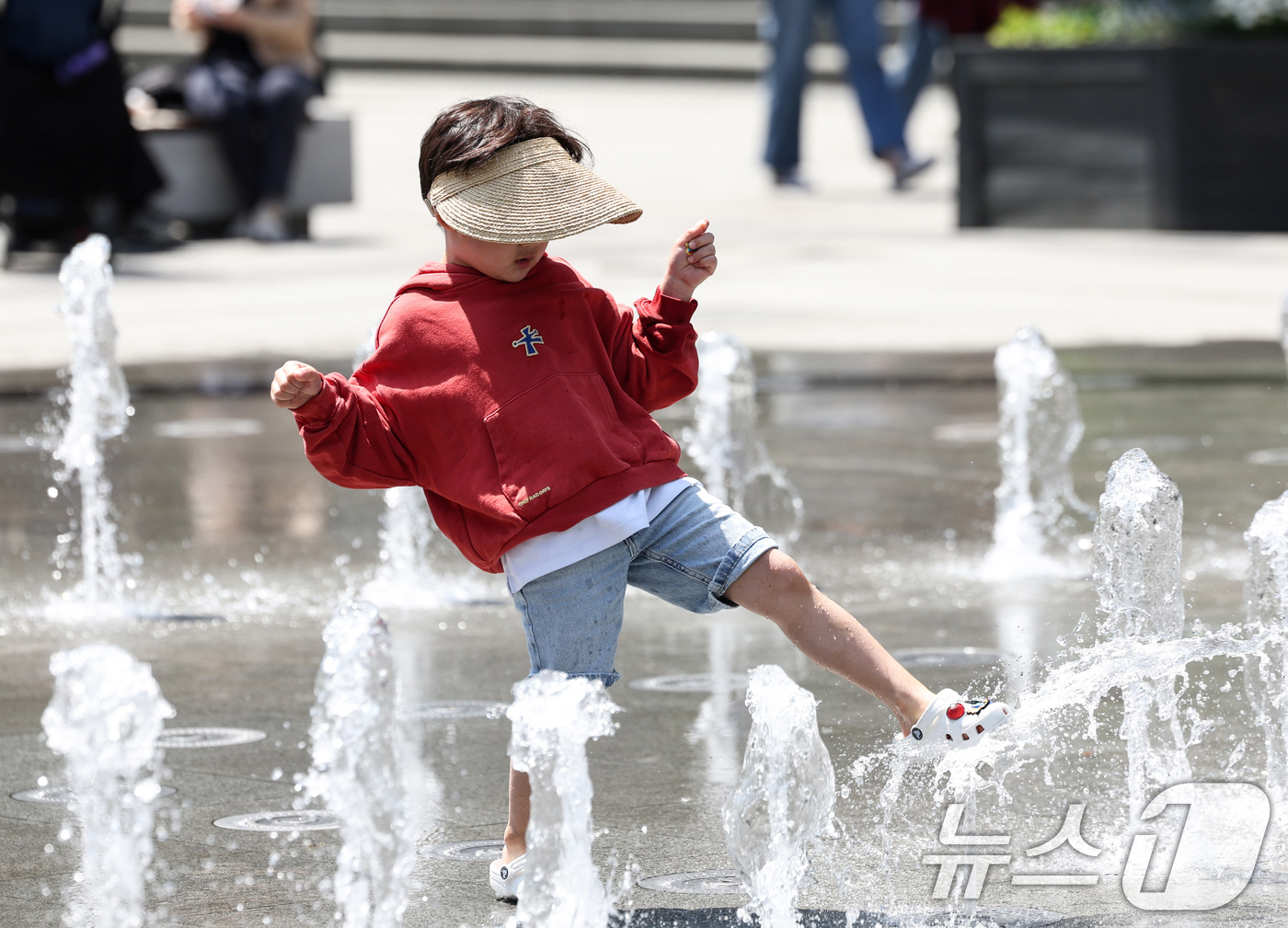 (서울=뉴스1) 임지훈 인턴기자 = 서울 낮 최고 기온이 22도까지 오르는 등 초여름 날씨를 보인 30일 서울 종로구 광화문광장 바닥분수를 찾은 한 어린이가 더위를 식히고 있다. …