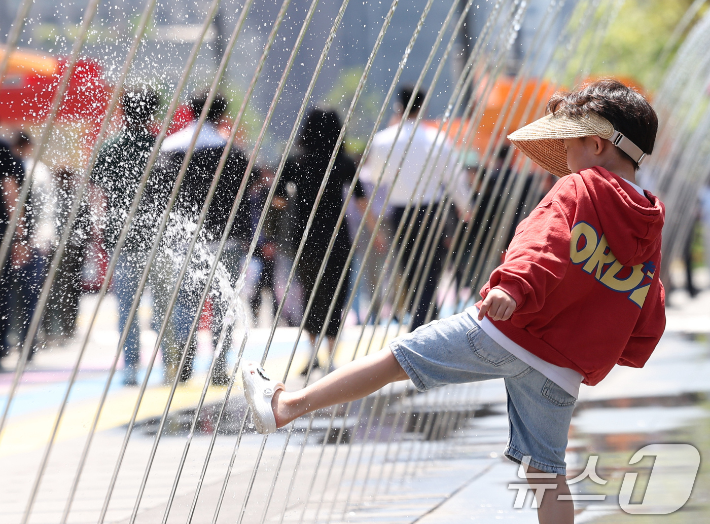 (서울=뉴스1) 임지훈 인턴기자 = 서울 낮 최고 기온이 22도까지 오르는 등 초여름 날씨를 보인 30일 서울 종로구 광화문광장 분수 터널을 찾은 한 아이가 물놀이를 하며 더위를 …