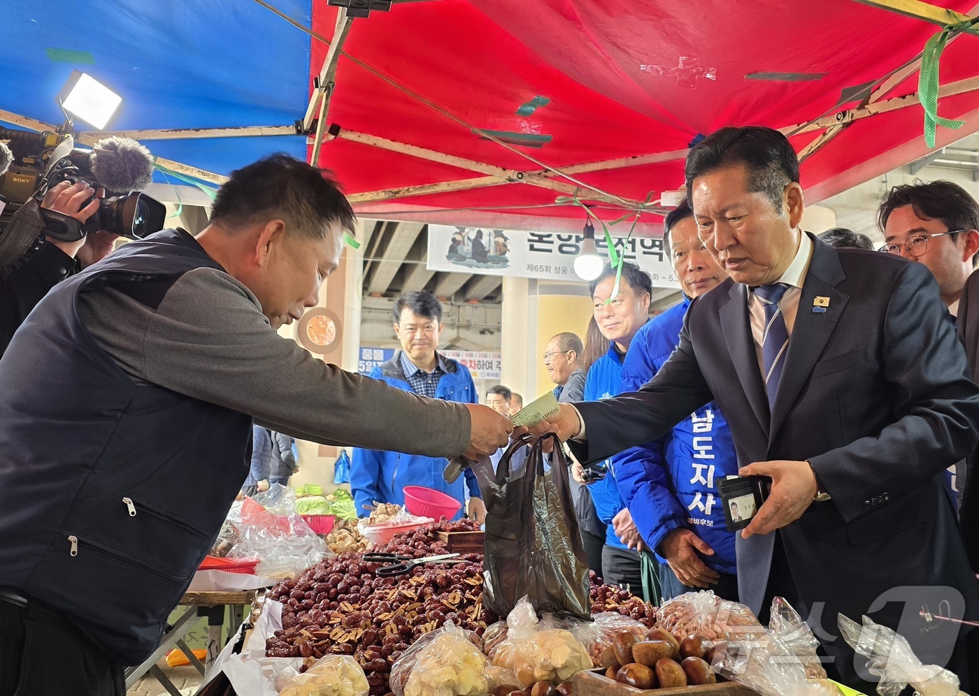 (아산=뉴스1) 이시우 기자 = 정청래 더불어민주당 대표가 4일 충남 아산 온양온천시장을 방문, 물건을 구입하고 있다.  2026.4.4/뉴스1