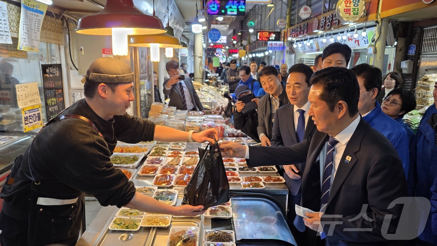 (아산=뉴스1) 이시우 기자 = 정청래 더불어민주당 대표가 4일 충남 아산 온양온천시장을 방문, 물건을 구입하고 있다.  2026.4.4/뉴스1