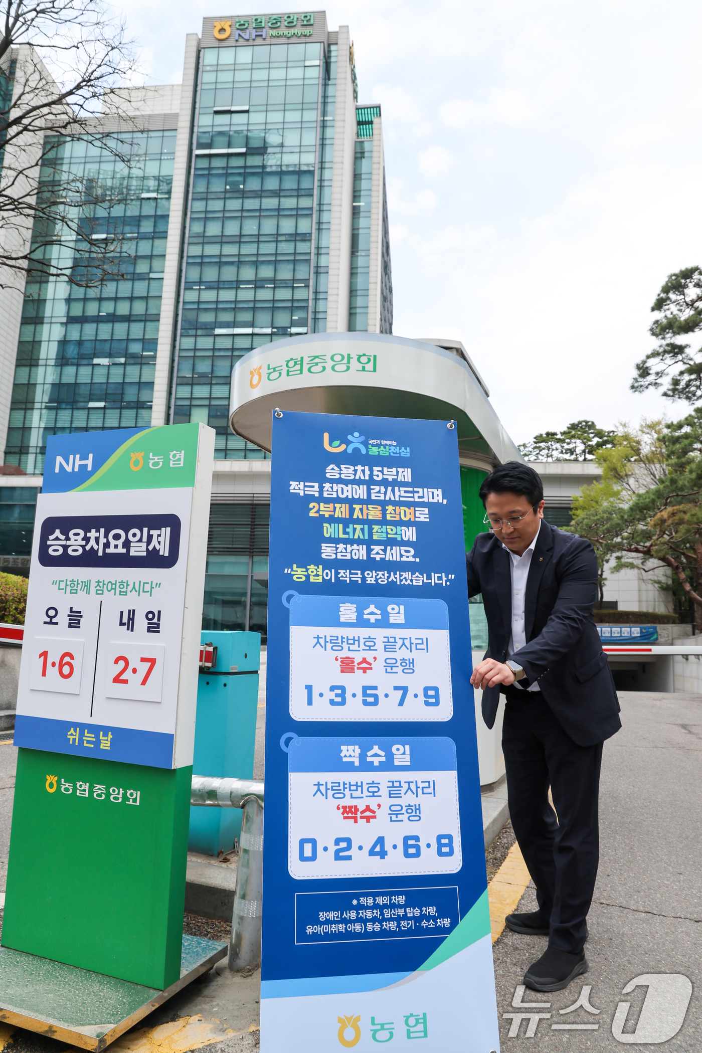 (서울=뉴스1) 안은나 기자 = 농협중앙회가 차량 2부제 자율 시행을 시작한 6일 서울 서대문구 농협중앙회 본관 주차장 입구에서 직원이 관련 안내문 배너를 설치하고 있다.농협은 정 …