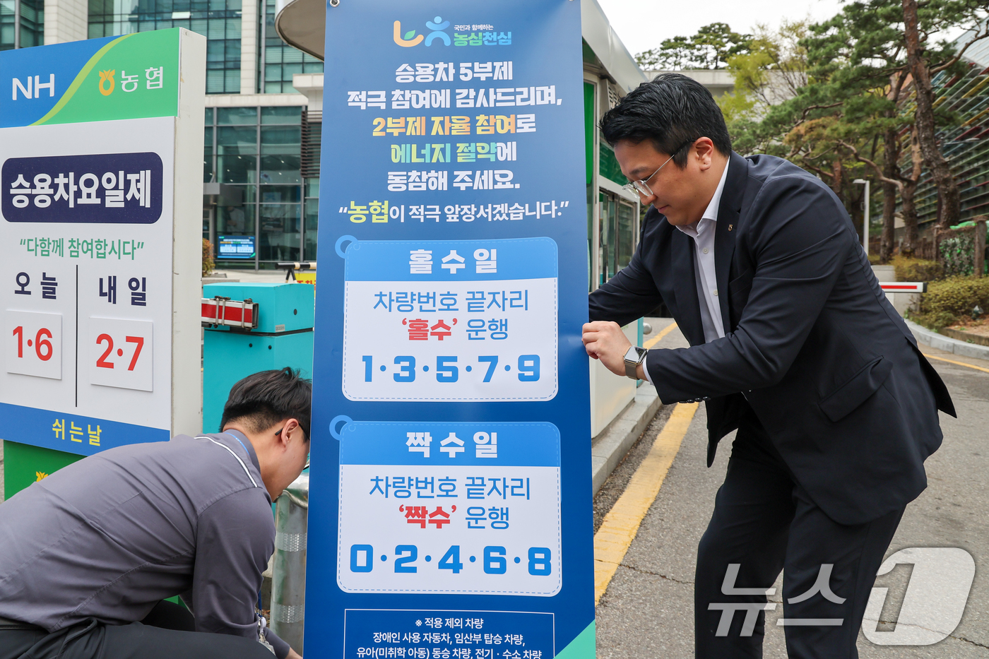 (서울=뉴스1) 안은나 기자 = 농협중앙회가 차량 2부제 자율 시행을 시작한 6일 서울 서대문구 농협중앙회 본관 주차장 입구에서 직원이 관련 안내문 배너를 설치하고 있다.농협은 정 …