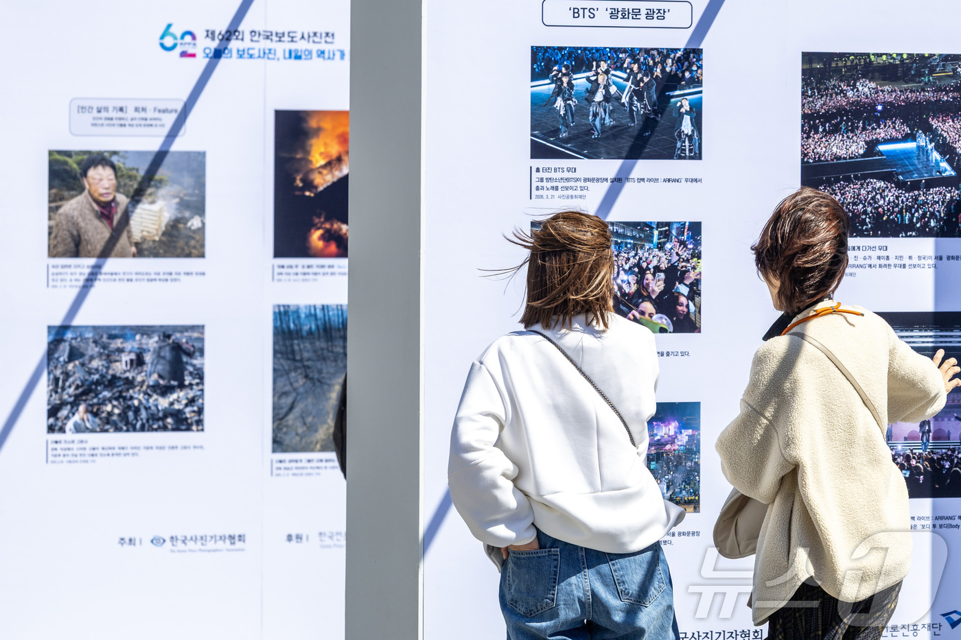 (서울=뉴스1) 사진공동취재단 = 7일 서울 종로구 광화문 광장에서 열린 제62회 한국보도사진전 ‘오늘의 보도사진, 내일의 역사가 되다’에서 시민들이 작품을 관람하고 있다. 202 …