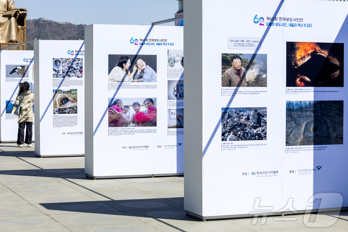 (서울=뉴스1) 사진공동취재단 = 7일 서울 종로구 광화문 광장에서 열린 제62회 한국보도사진전 ‘오늘의 보도사진, 내일의 역사가 되다’에서 시민이 작품을 관람하고 있다.  202 …