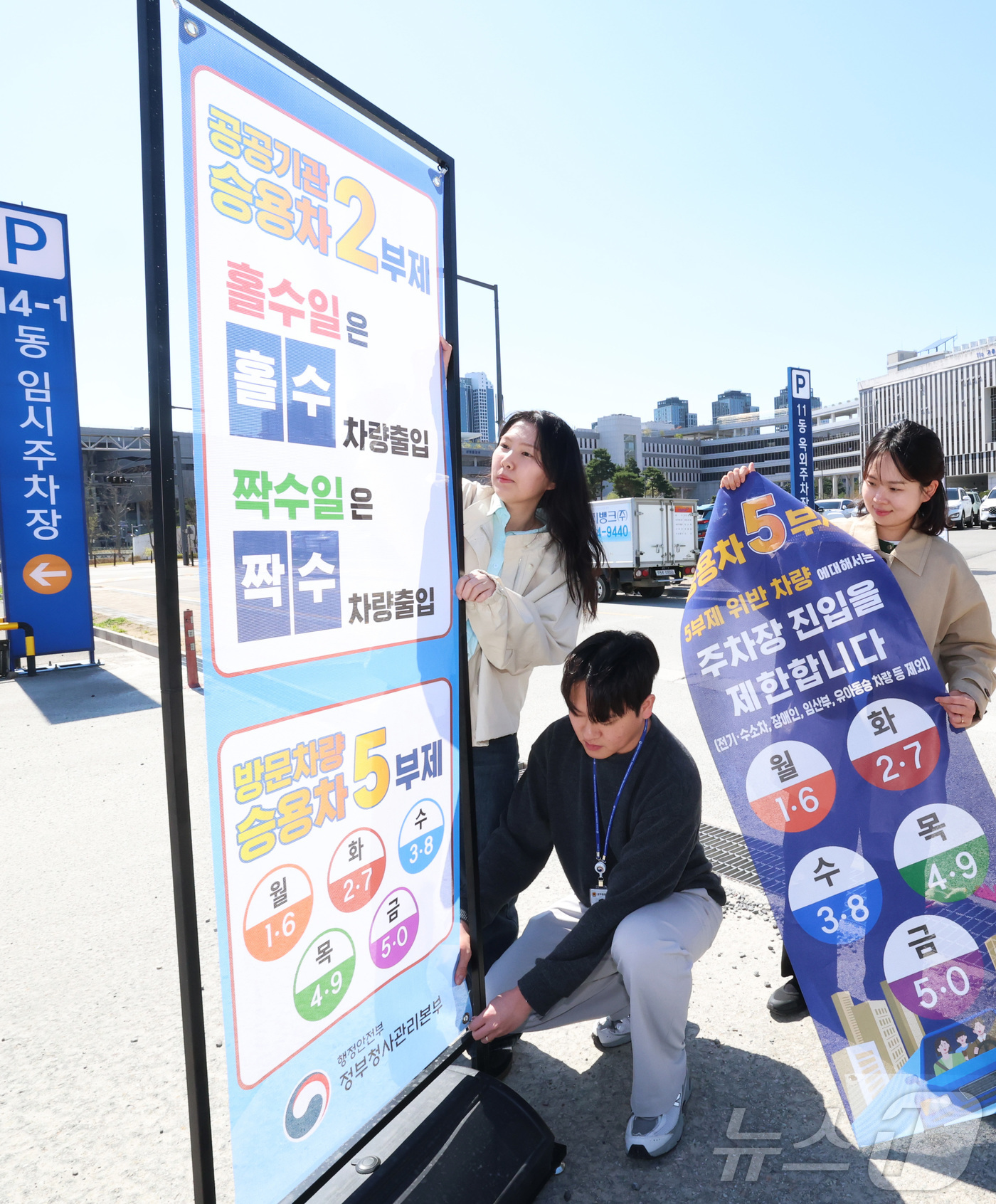 (세종=뉴스1) 김기남 기자 = 7일 세종시 정부세종청사 주차장에서 정부청사관리본부 직원들이 공공기관 차량2부제 및 방문차량 5부제 시행을 알리는 안내문을 게시하고 있다.중동 전쟁 …