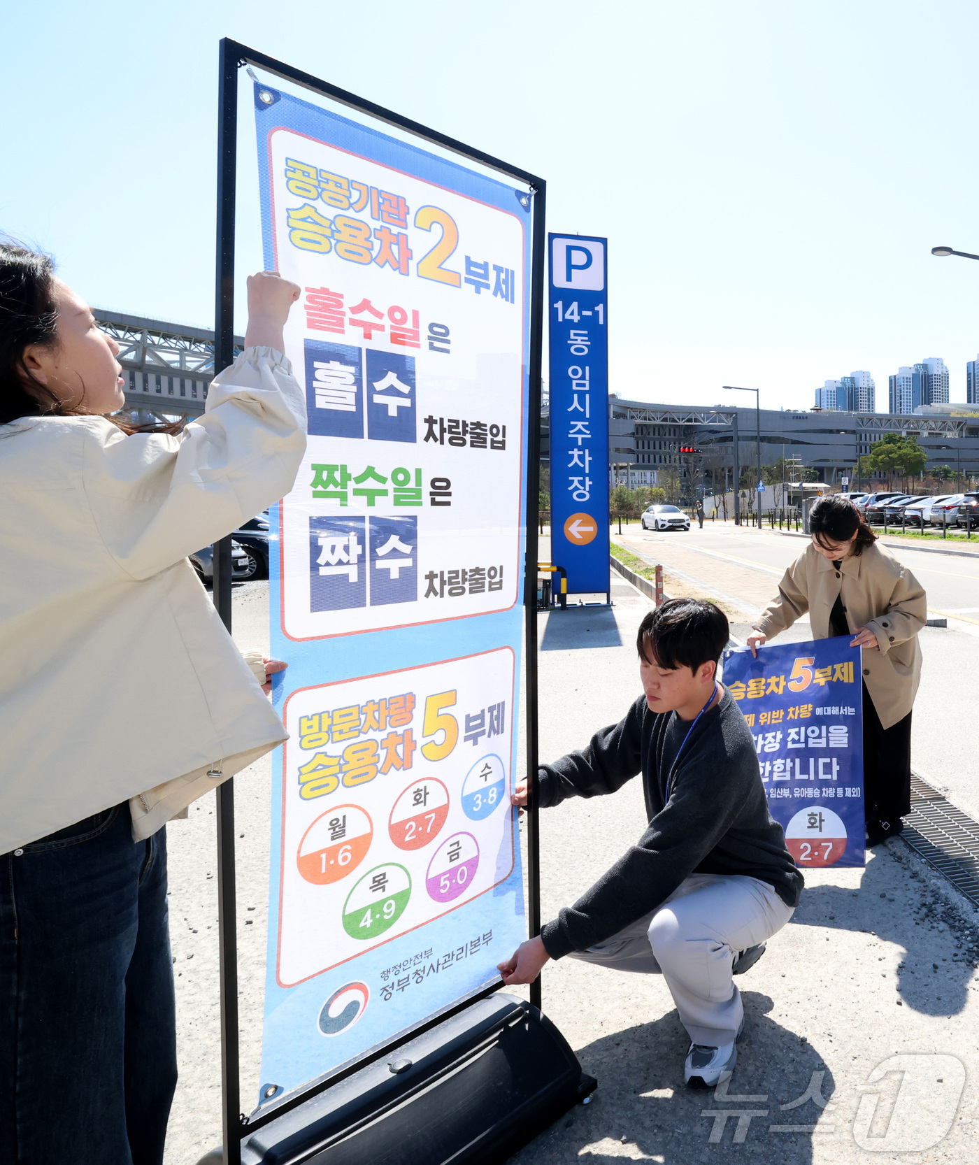 (세종=뉴스1) 김기남 기자 = 7일 세종시 정부세종청사 주차장에서 정부청사관리본부 직원들이 공공기관 차량2부제 및 방문차량 5부제 시행을 알리는 안내문을 게시하고 있다.중동 전쟁 …