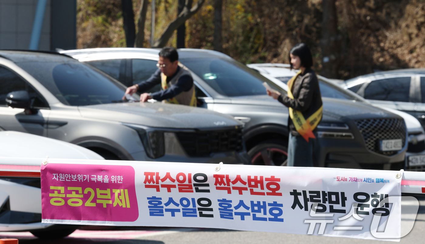 (군포=뉴스1) 김영운 기자 = 공공기관 승용차 2부제 시행을 하루 앞둔 7일 경기 군포시 금정동 군포시청 직원주차장에서 직원들이 공공기관 2부제 협조 안내문을 부착하고 있다.이번 …