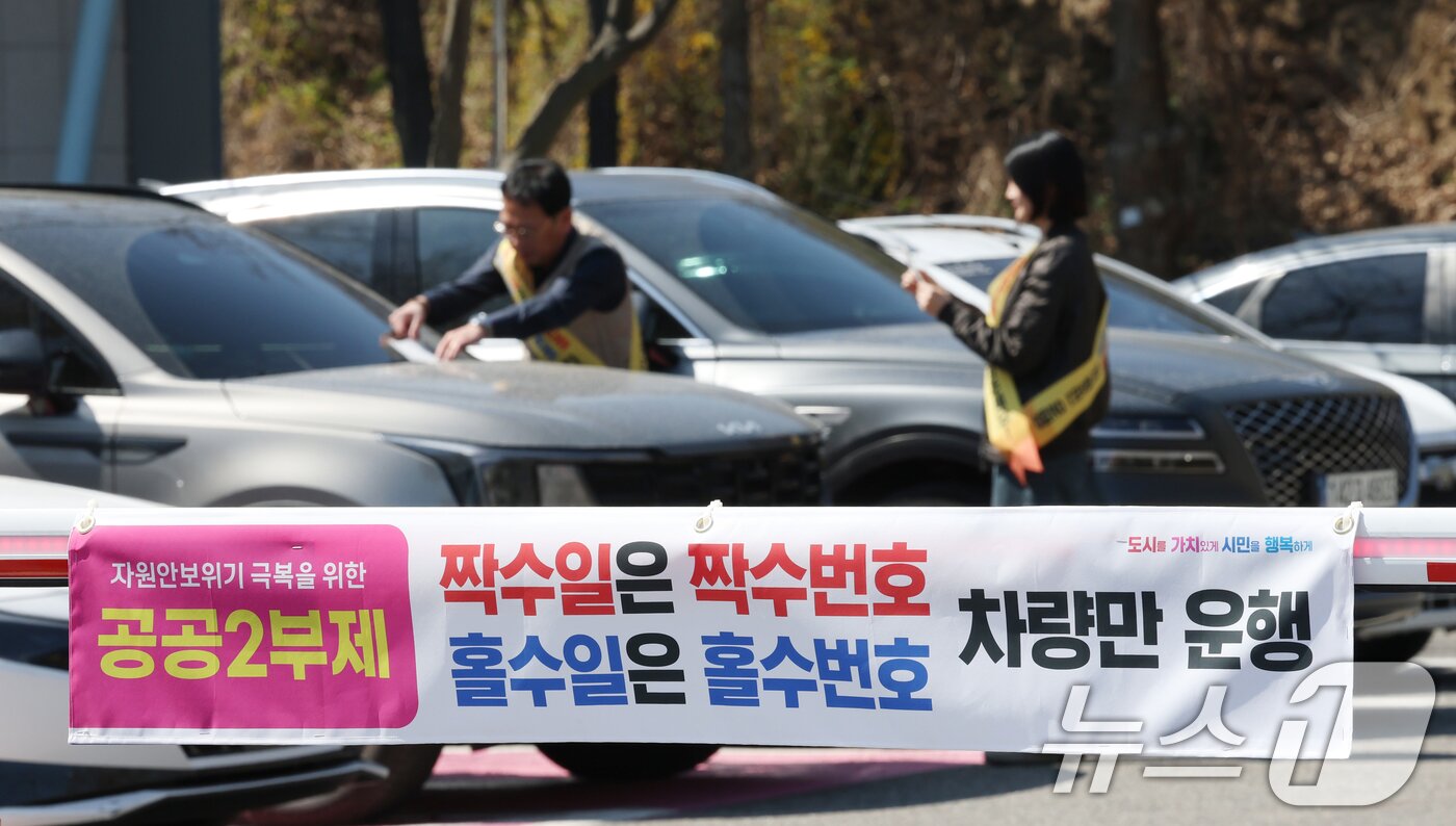 본문 이미지 - 공공기관 승용차 2부제 시행을 하루 앞둔 7일 경기 군포시 금정동 군포시청 직원주차장에서 직원들이 공공기관 2부제 협조 안내문을 부착하고 있다.  2026.4.7 ⓒ 뉴스1 김영운 기자