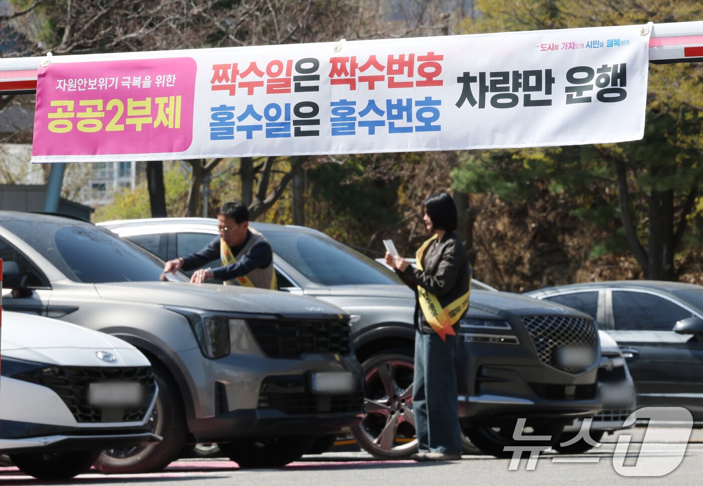본문 이미지 - 공공기관 승용차 2부제 시행을 하루 앞둔 7일 경기 군포시 금정동 군포시청 직원주차장에서 직원들이 공공기관 2부제 협조 안내문을 부착하고 있다. 2026.4.7 ⓒ 뉴스1 김영운 기자