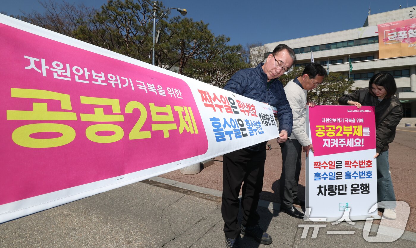 본문 이미지 - 공공기관 승용차 2부제 시행을 하루 앞둔 7일 경기 군포시 금정동 군포시청 직원주차장에서 직원들이 공공기관 2부제를 알리는 현수막을 부착하고 있다. 2026.4.7 ⓒ 뉴스1 김영운 기자