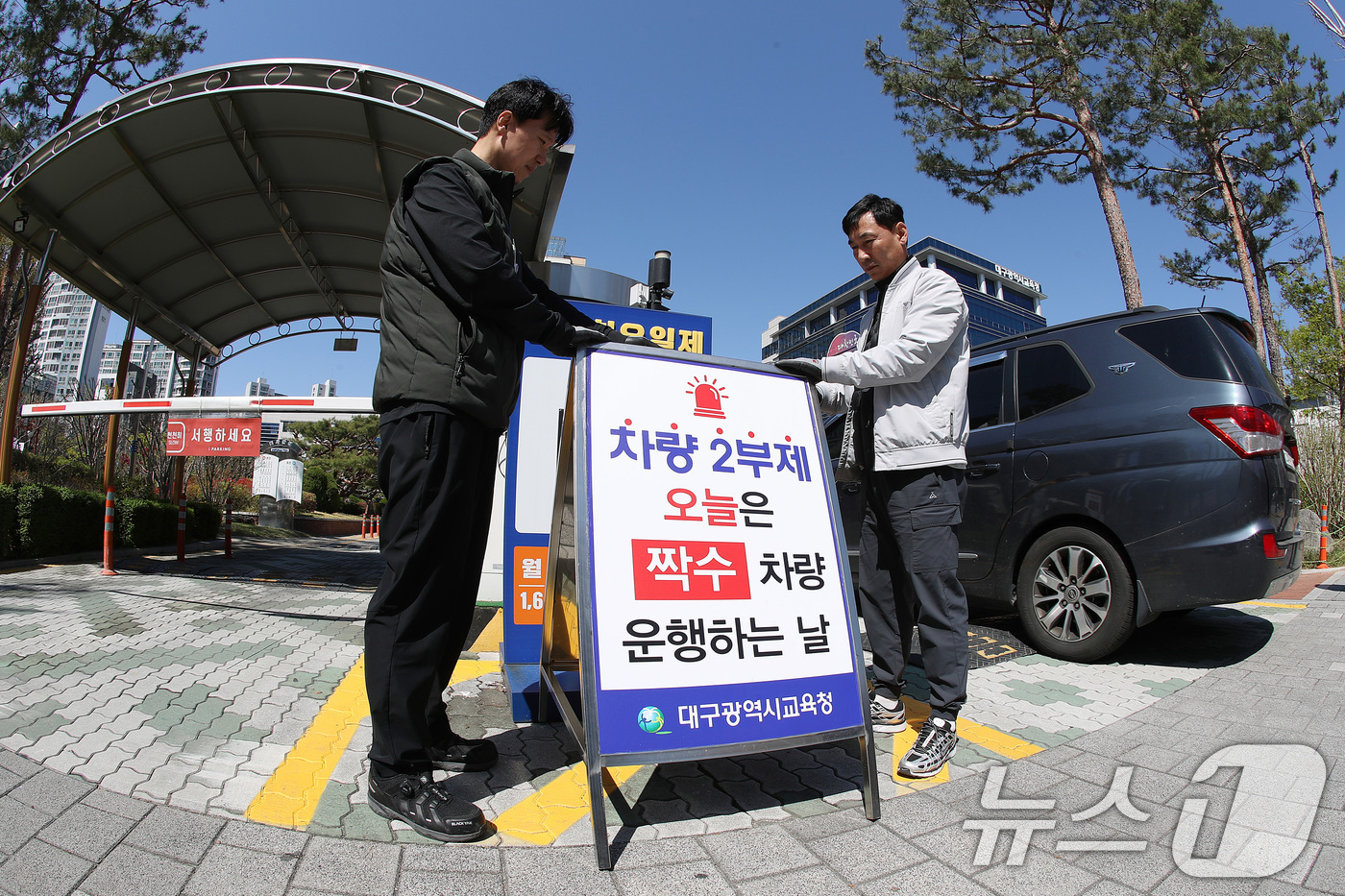 (대구=뉴스1) 공정식 기자 = '공공기관 차량 2부제' 시행을 하루 앞둔 7일 오후 대구시교육청 관계자들이 정문 차량 출입구에 차량 2부제를 알리는 입간판을 설치하고 있다. 20 …