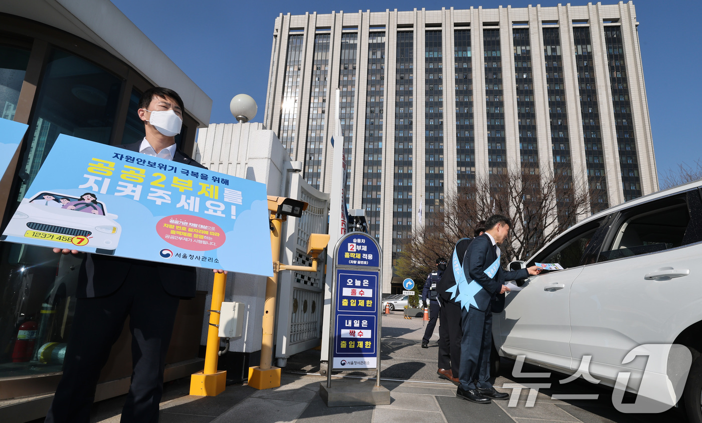 (서울=뉴스1) 임세영 기자 = 8일 서울 종로구 정부서울청사 앞에서 청사 직원들이 자원 안보 위기 경보가 3단계인 '경계' 단계로 격상됨에 따른 공공기관 차량 2부제 캠페인을 벌 …