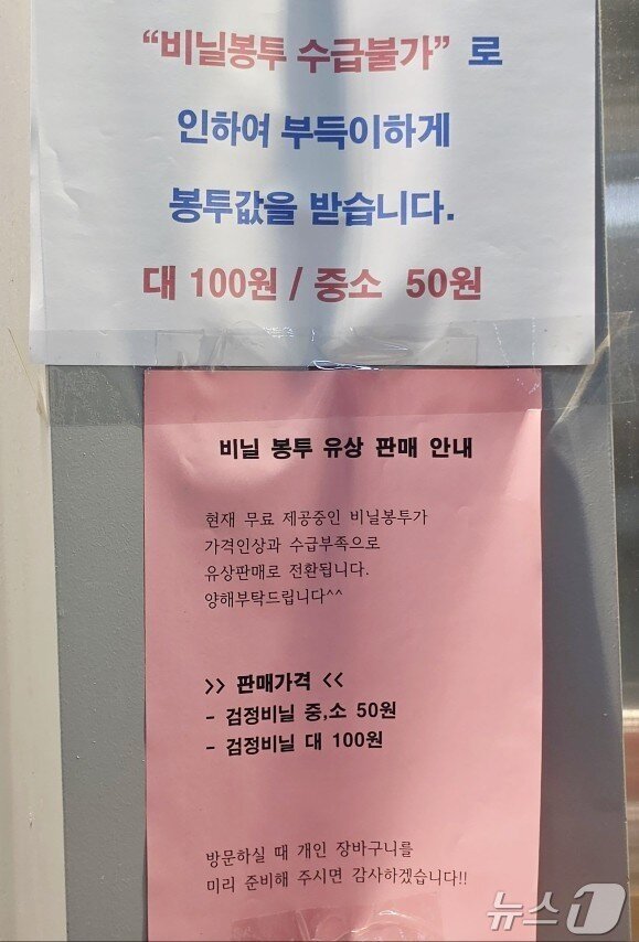 본문 이미지 - 비닐봉투 수급불가로 봉투값을 받는다고 공지를 붙여놓은 가게.  ⓒ 뉴스1 이재상 기자