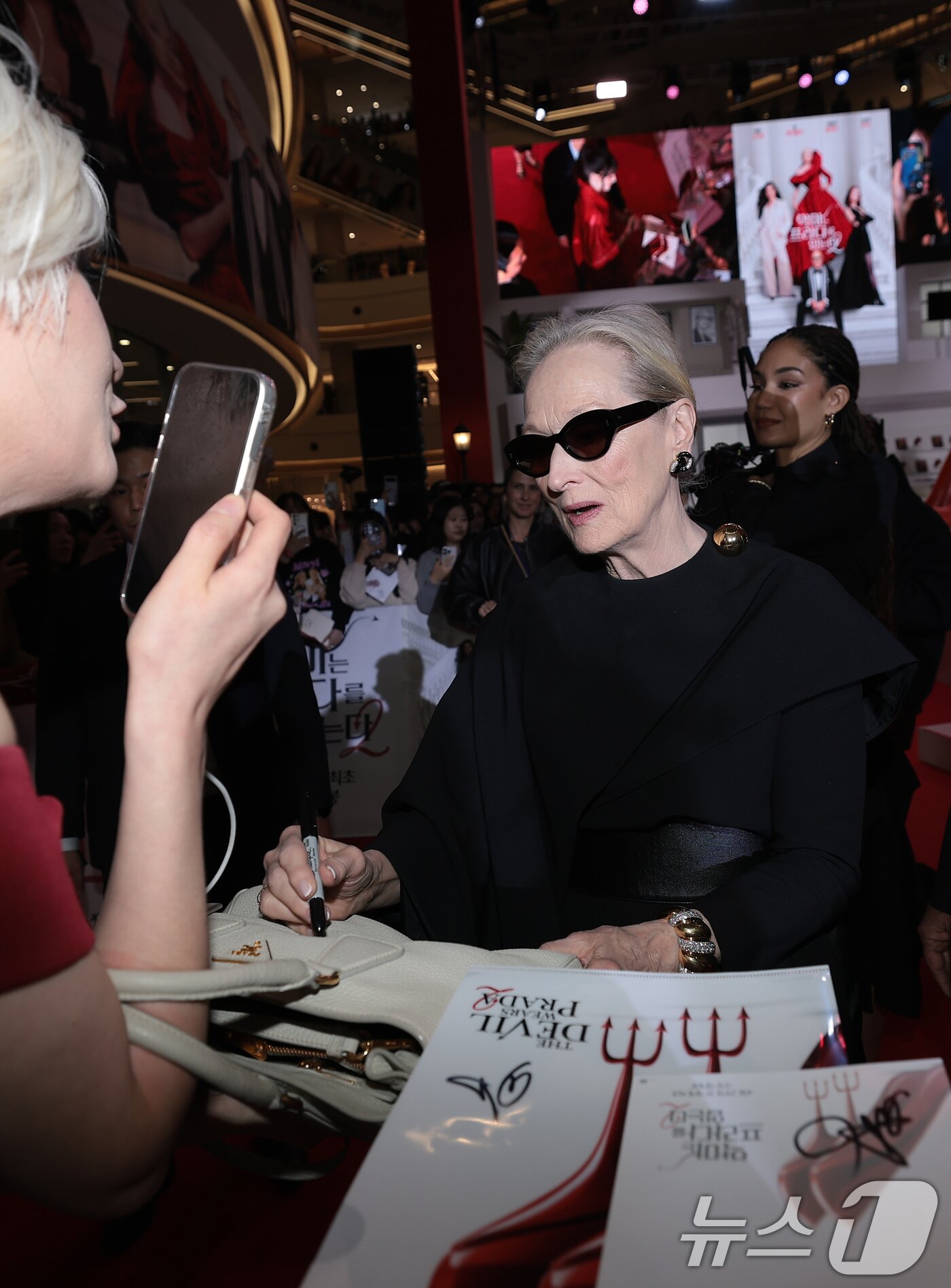 본문 이미지 - 배우 메릴 스트립이 8일 서울 영등포구 타임스퀘어에서 열린 영화 ‘악마는 프라다를 입는다 2’(감독 데이빗 프랭클) 레드카펫 행사에 참석해 팬에게 사인을 해 주고 있다. 2026.4.8 ⓒ 뉴스1 권현진 기자