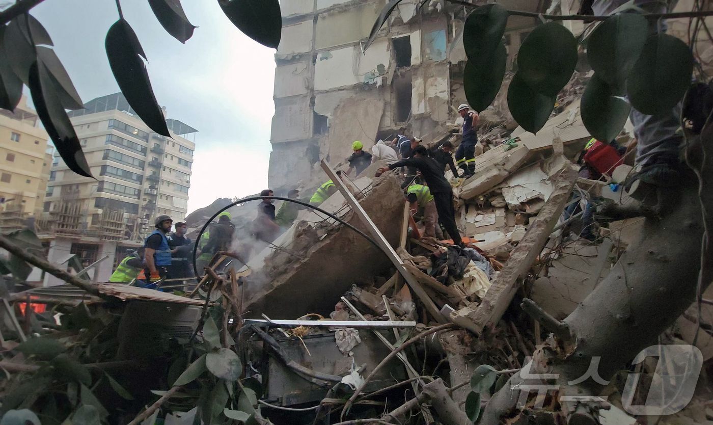 본문 이미지 - 8일(현지시간) 레바논 베이루트 탈레트 알-카이야트 지구의 이스라엘의 공습 현장에 구조대원과 주민들이 모여 있다. 2026.04.08. ⓒ AFP=뉴스1