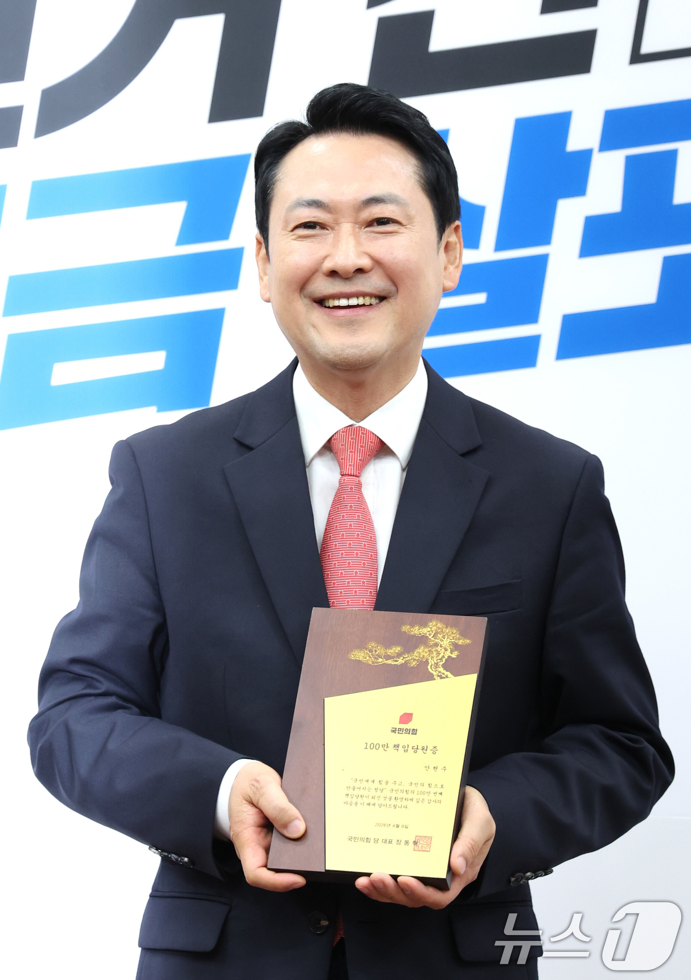 (서울=뉴스1) 신웅수 기자 = 장동혁 국민의힘 대표가 9일 서울 여의도 국회에서 열린 국민의힘 100만 책임당원 돌파 기념식에서 100만 책임당원증을 들고 있다. 2026.4.9 …
