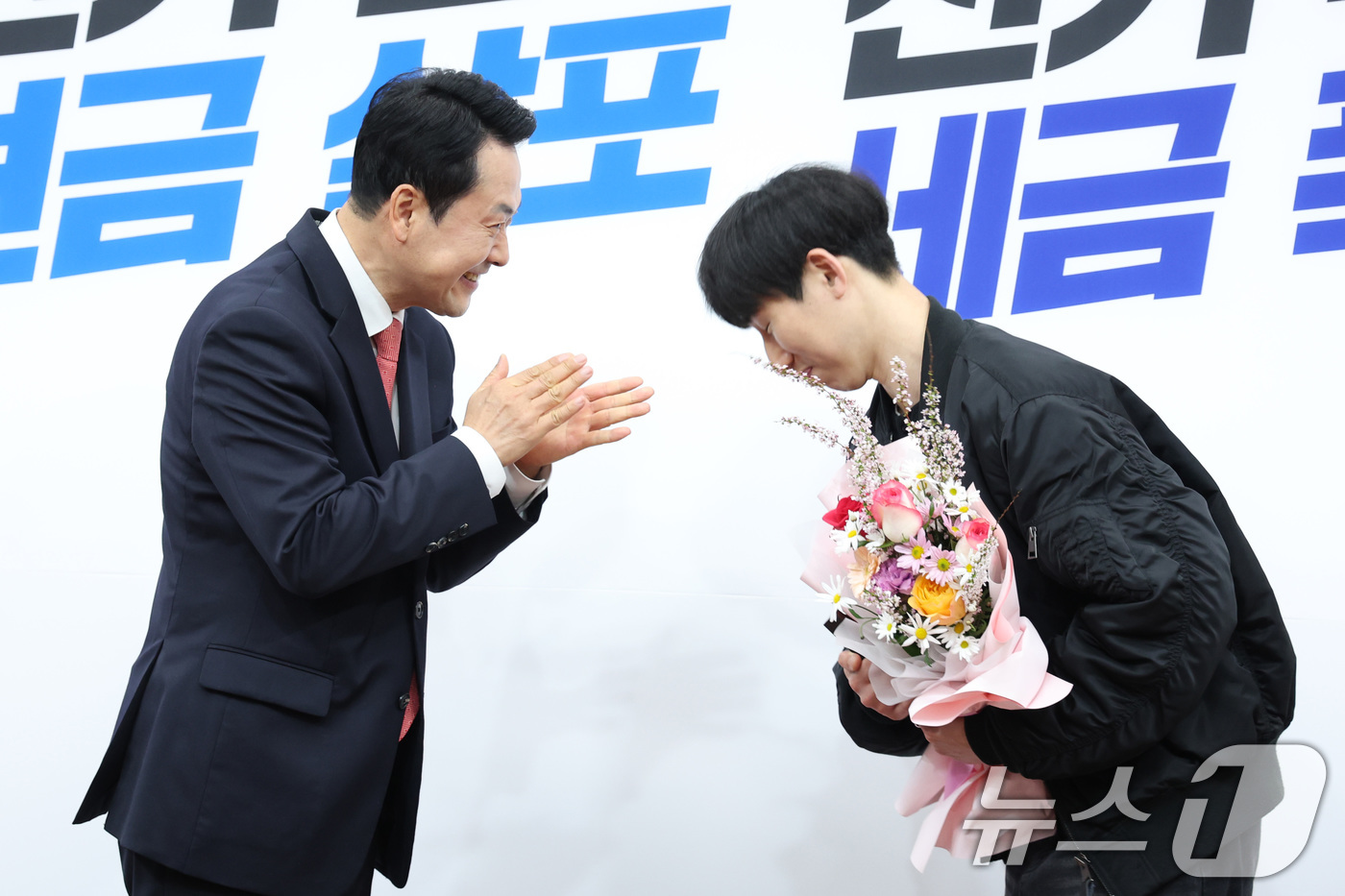 (서울=뉴스1) 신웅수 기자 = 장동혁 국민의힘 대표가 9일 서울 여의도 국회에서 열린 국민의힘 100만 책임당원 돌파 기념식에서 책임당원에게 꽃다발을 전달하고 있다. 2026.4 …