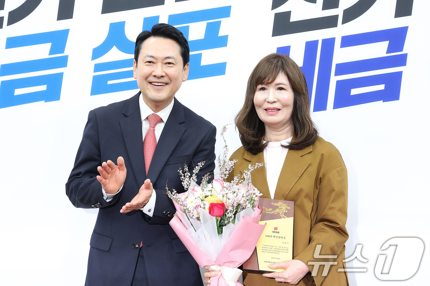 (서울=뉴스1) 신웅수 기자 = 장동혁 국민의힘 대표가 9일 서울 여의도 국회에서 열린 국민의힘 100만 책임당원 돌파 기념식에서 책임당원과 기념 촬영을 하고 있다. 2026.4. …