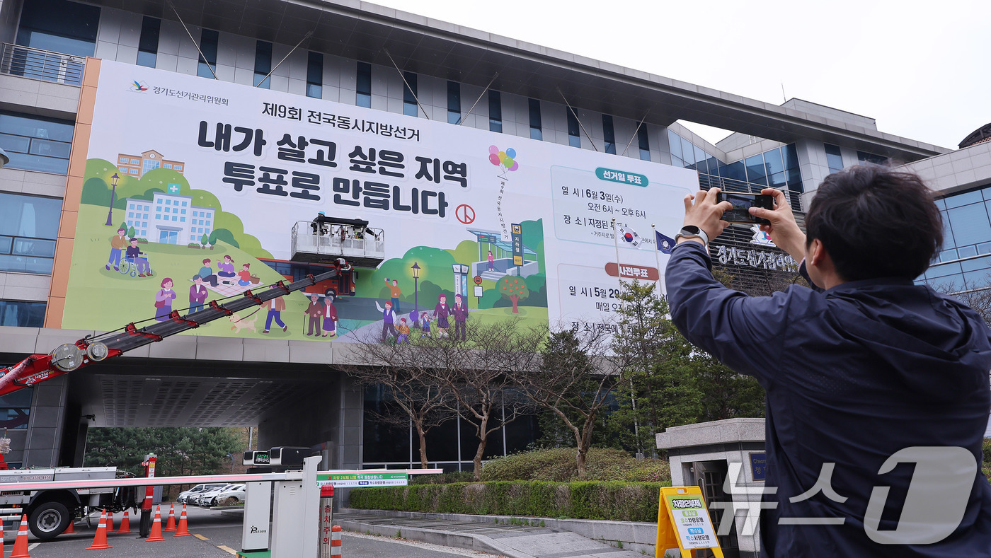 (수원=뉴스1) 박지혜 기자 = 제9회 전국동시지방선거를 앞둔 9일 경기도 수원시 영통구 경기도선거관리위원회 청사 외벽에 관계자들이 투표참여를 독려하는 대형 현수막을 설치하고 있다 …