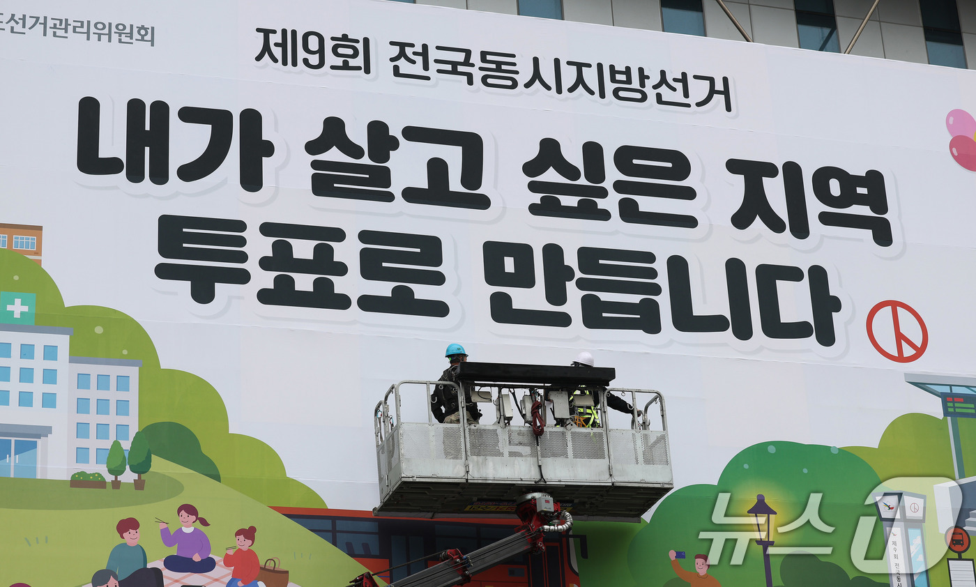 (수원=뉴스1) 박지혜 기자 = 제9회 전국동시지방선거를 앞둔 9일 경기도 수원시 영통구 경기도선거관리위원회 청사 외벽에 관계자들이 투표참여를 독려하는 대형 현수막을 설치하고 있다 …