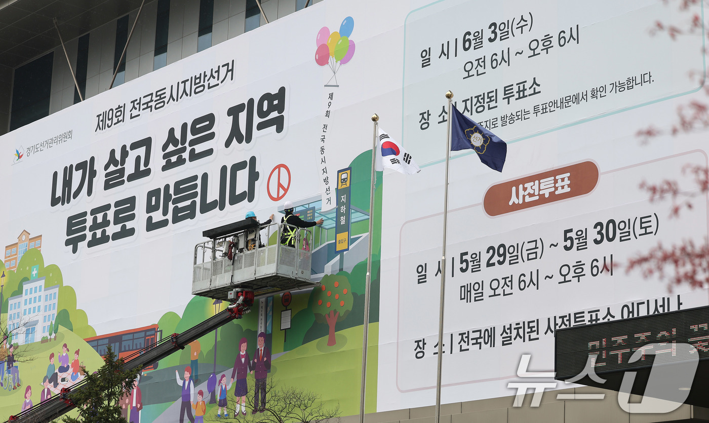 (수원=뉴스1) 박지혜 기자 = 제9회 전국동시지방선거를 앞둔 9일 경기도 수원시 영통구 경기도선거관리위원회 청사 외벽에 관계자들이 투표참여를 독려하는 대형 현수막을 설치하고 있다 …