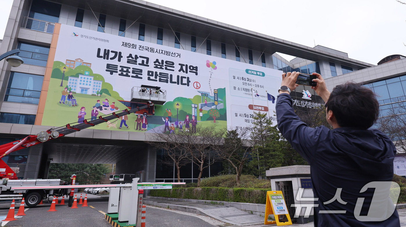 (수원=뉴스1) 박지혜 기자 = 제9회 전국동시지방선거를 앞둔 9일 경기도 수원시 영통구 경기도선거관리위원회 청사 외벽에 관계자들이 투표참여를 독려하는 대형 현수막을 설치하고 있다 …