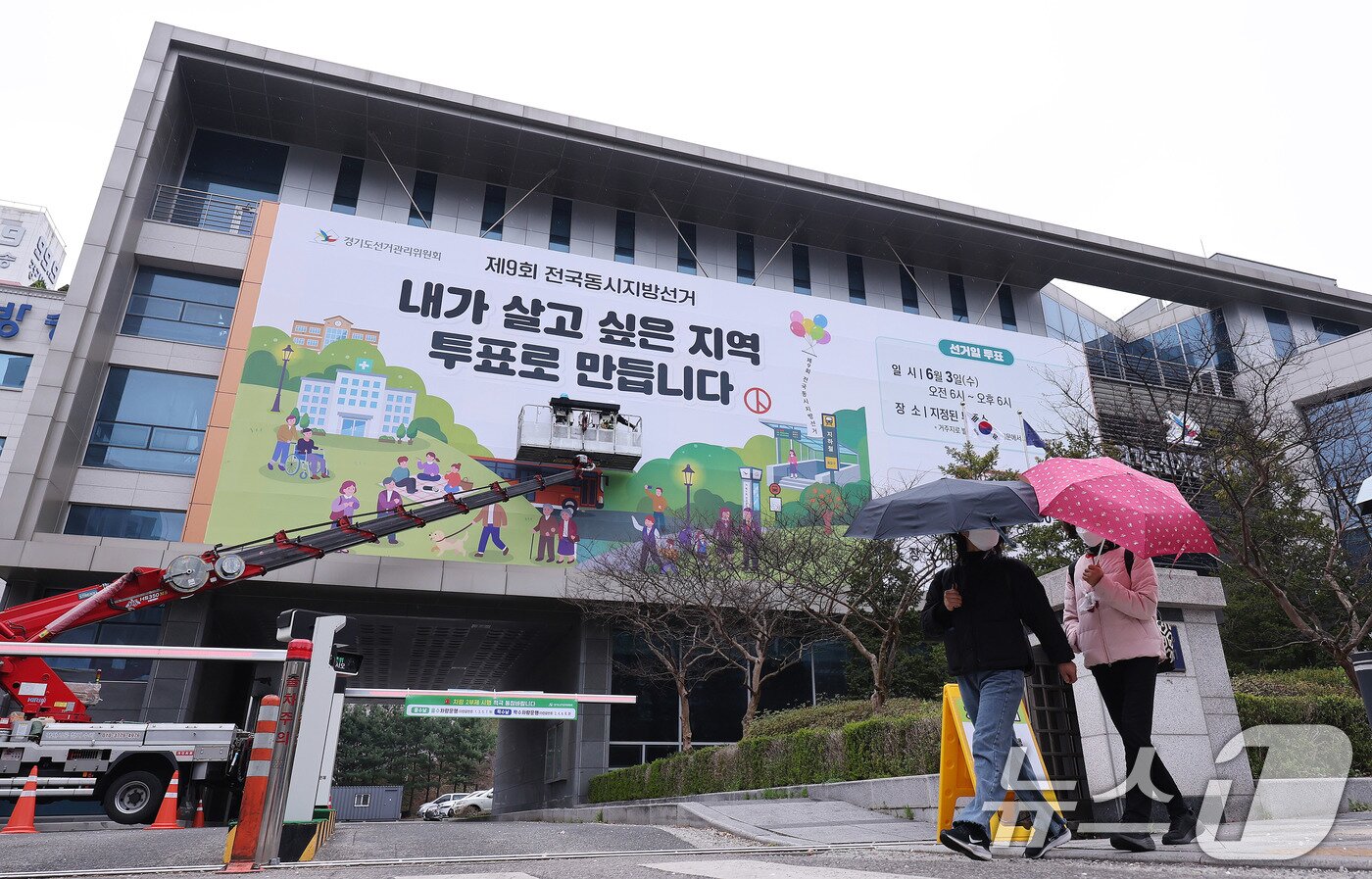 본문 이미지 - 제9회 전국동시지방선거를 앞둔 9일 경기도 수원시 영통구 경기도선거관리위원회 청사 외벽에 관계자들이 투표참여를 독려하는 대형 현수막을 설치하고 있다. 2026.4.9 ⓒ 뉴스1 박지혜 기자