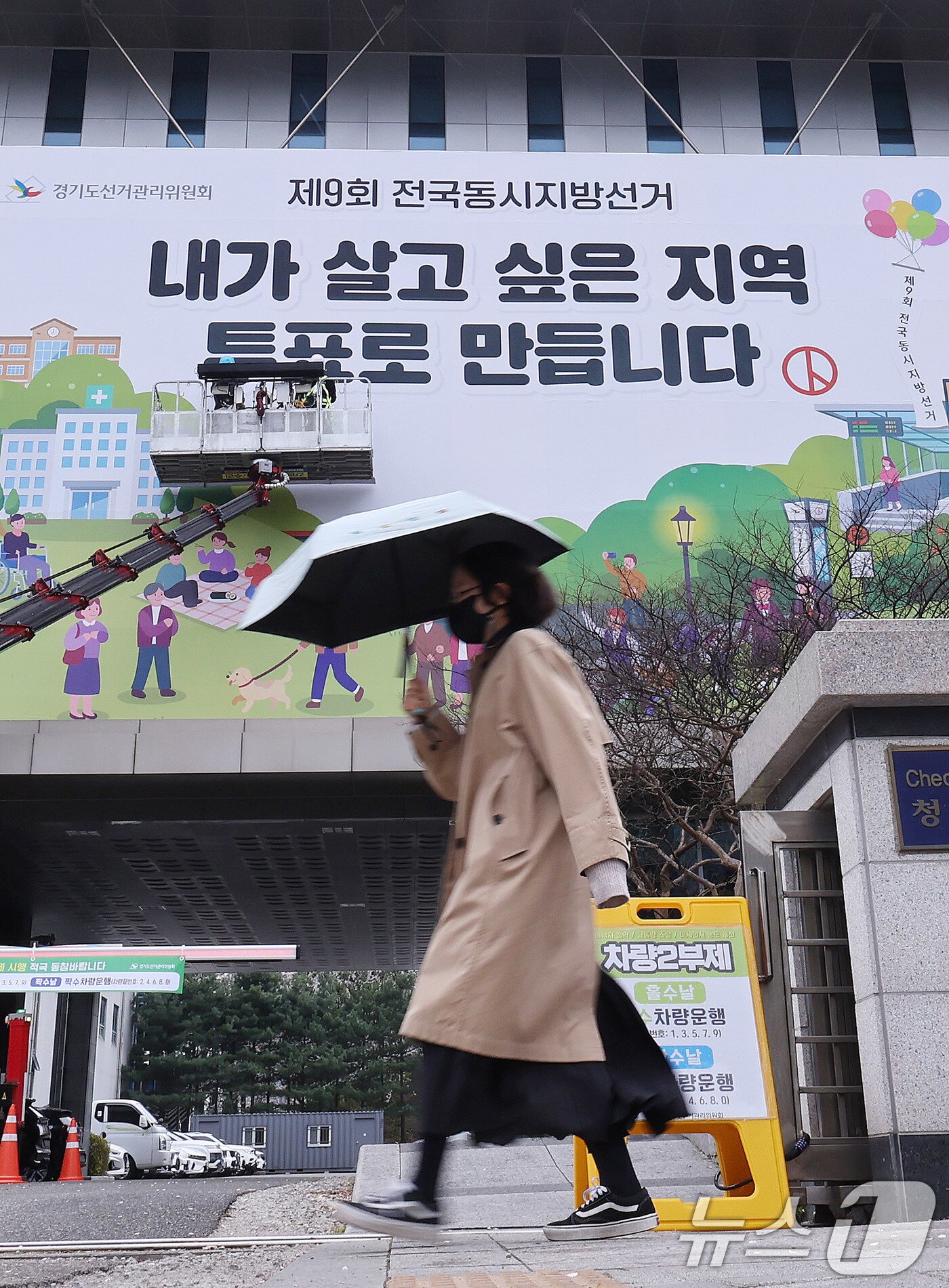 본문 이미지 - 제9회 전국동시지방선거를 앞둔 9일 경기도 수원시 영통구 경기도선거관리위원회 청사 외벽에 관계자들이 투표참여를 독려하는 대형 현수막을 설치하고 있다. 2026.4.9 ⓒ 뉴스1 박지혜 기자