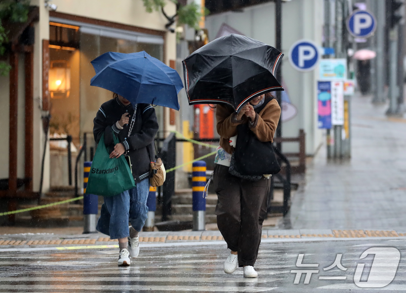 (부산=뉴스1) 윤일지 기자 = 전국적으로 비가 내리는 9일 오후 부산 해운대해수욕장 인근에서 외국인 관광객들이 강풍에 우산을 부여잡고 힘겹게 발걸음을 옮기고 있다.  2026.4 …