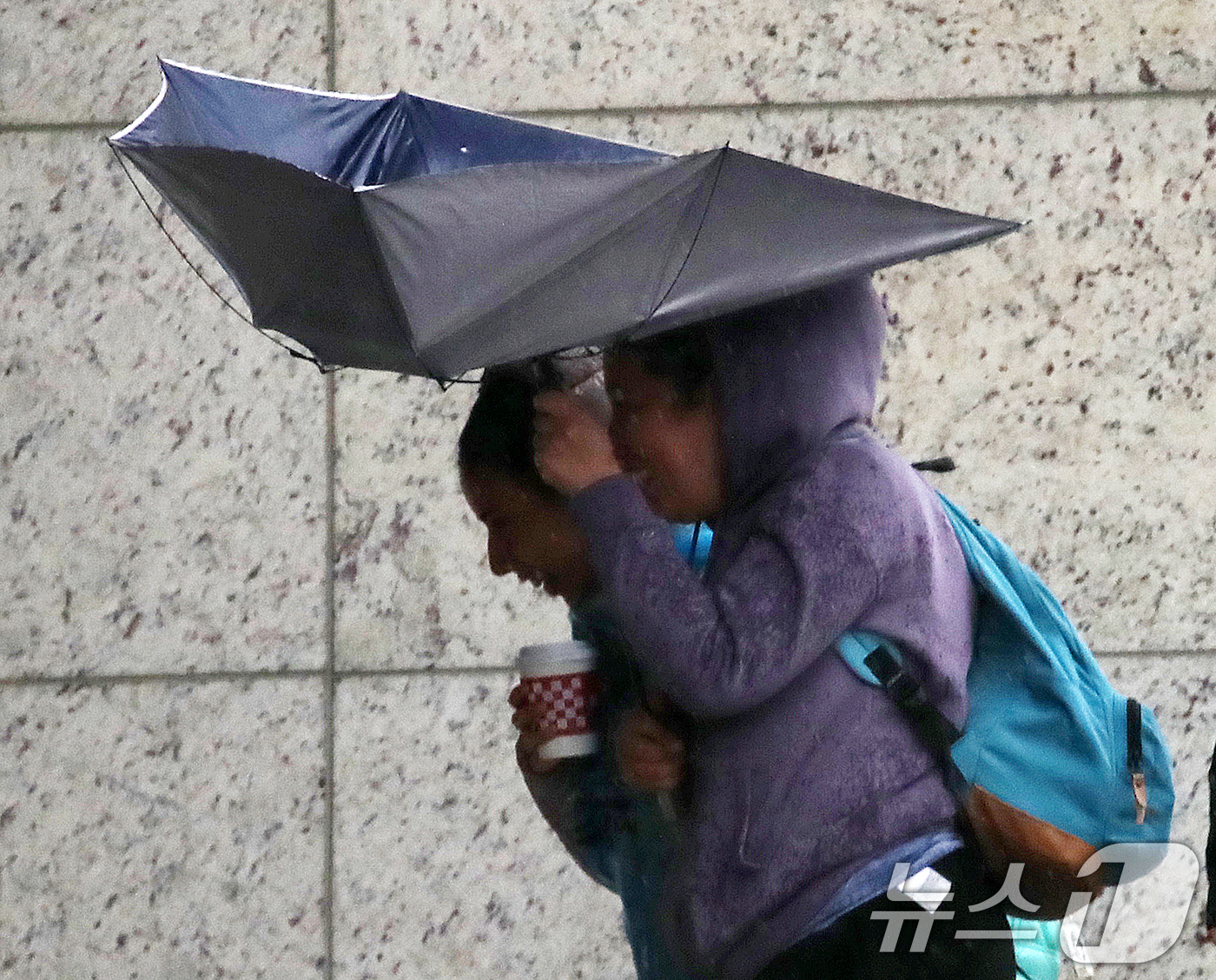 (부산=뉴스1) 윤일지 기자 = 전국적으로 비가 내리는 9일 오후 부산 해운대해수욕장 인근에서 외국인 관광객들이 강풍에 우산을 부여잡고 힘겹게 발걸음을 옮기고 있다.  2026.4 …