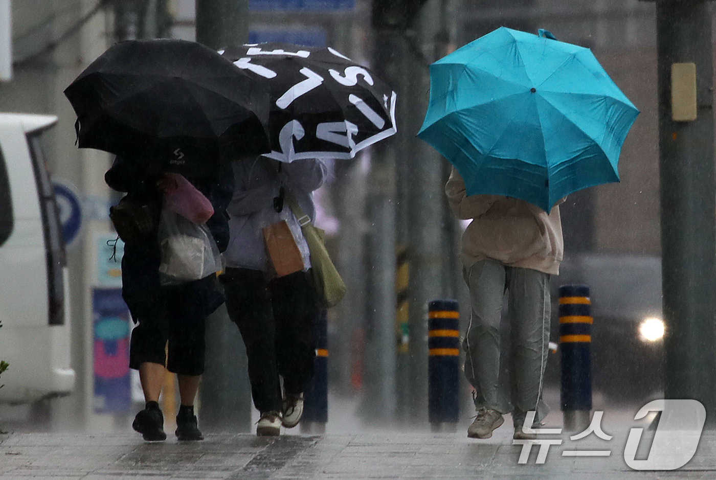 (부산=뉴스1) 윤일지 기자 = 전국적으로 비가 내리는 9일 오후 부산 해운대해수욕장 인근에서 시민들이 강풍에 우산을 부여잡고 힘겹게 발걸음을 옮기고 있다.  2026.4.9/뉴스 …