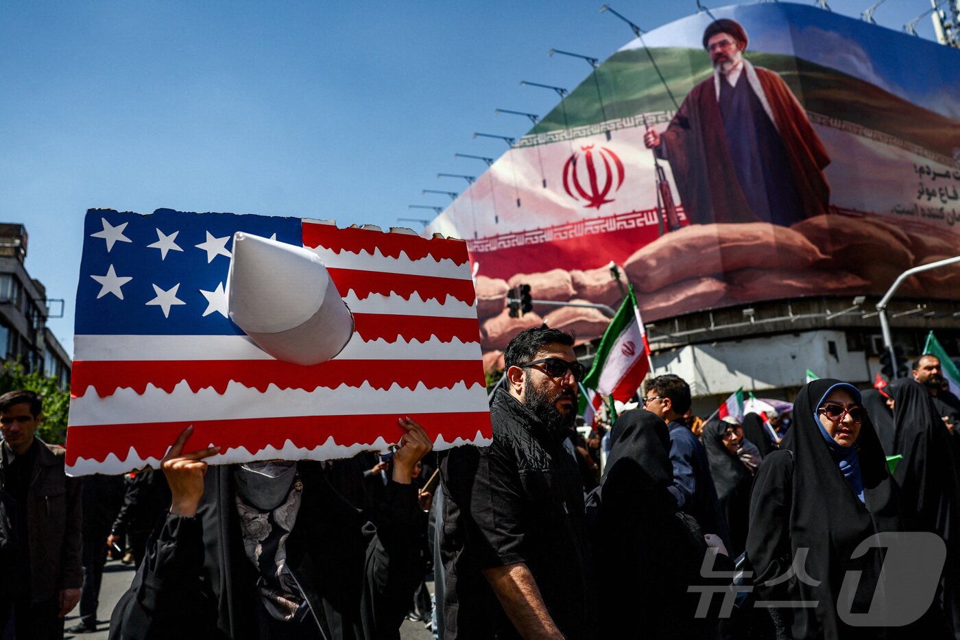 본문 이미지 - 이란 테헤란에서 열린 아야톨라 알리 하메네이 사망 40일 추모식. 참가자들 뒤로 새 최고지도자 모즈타바 하메네이의 사진이 보인다. 2026.04.09 ⓒ 로이터=뉴스1