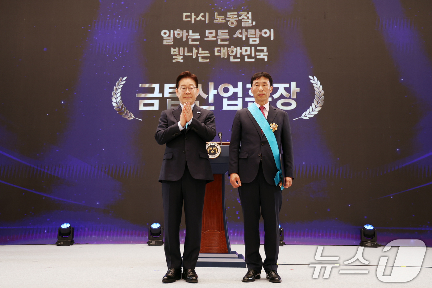 (서울=뉴스1) 허경 기자 = 이재명 대통령이 1일 청와대 영빈관에서 열린 2026 노동절 기념식에서 이유범 지승ENG 품질관리부장에게 금탑산업훈장을 수여하고 기념촬영을 하고 있다 …
