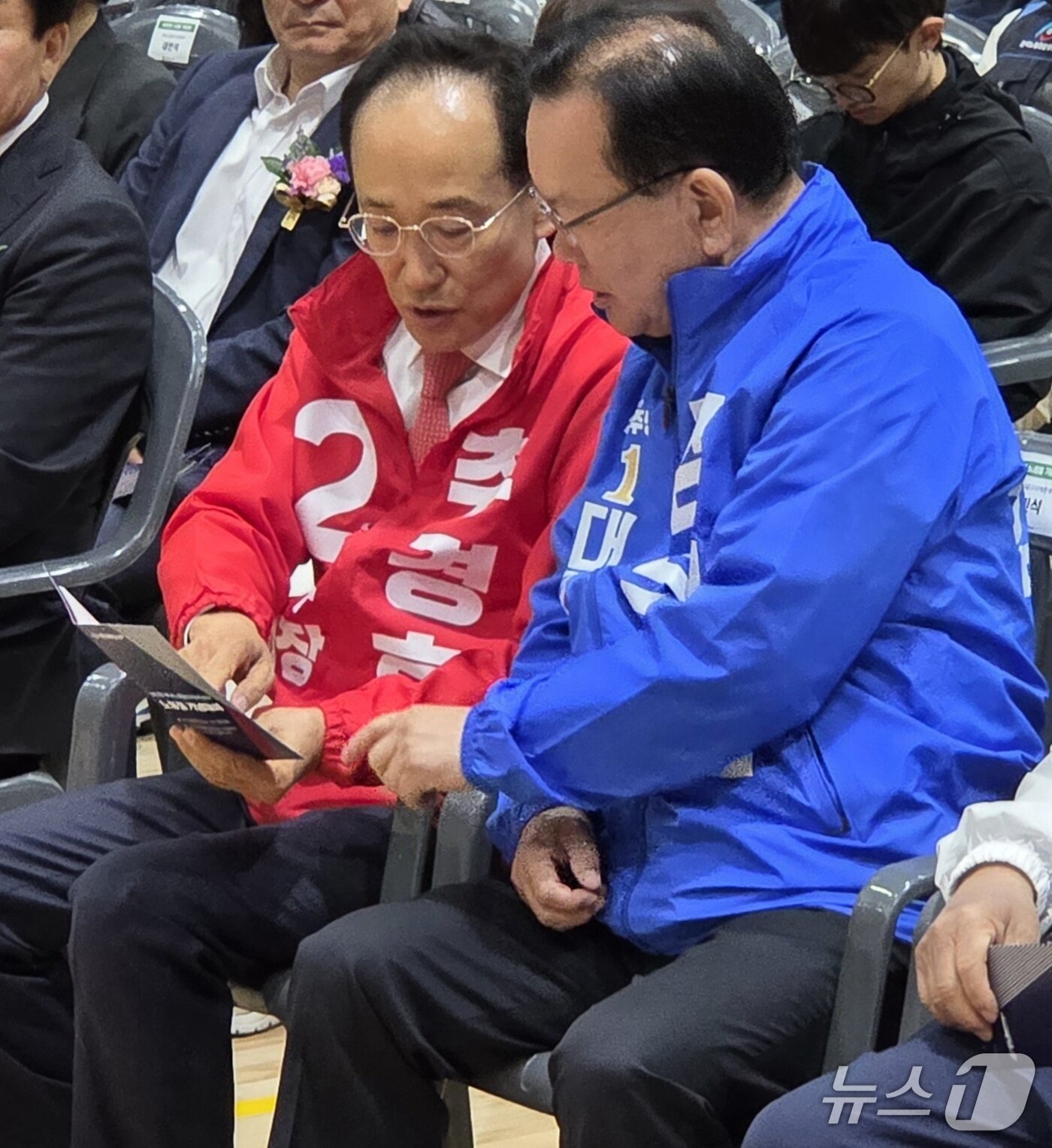 본문 이미지 - 노동절인 1일 오전 추경호 국민의힘 대구시장 후보와 김부겸 더불어민주당 후보가 자리에 앉아 기념대회 안내책자를 나란히 보고 있다.2026.5.1 ⓒ 뉴스1 이성덕 기자