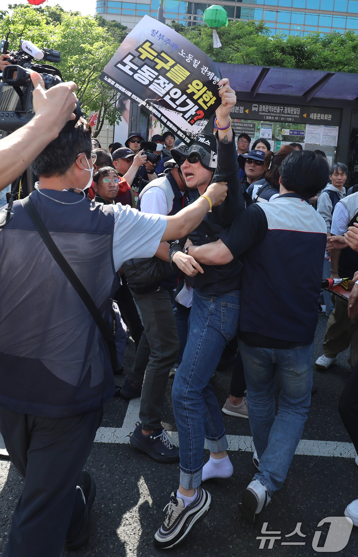 (서울=뉴스1) 안은나 기자 = '노동절 관제행사를 반대하며 노동해방을 위해 행동하는 활동가 모임' 손팻말을 든 시민이 1일 오후 서울 종로구 광화문광장에서 열린 민주노총 2026 …