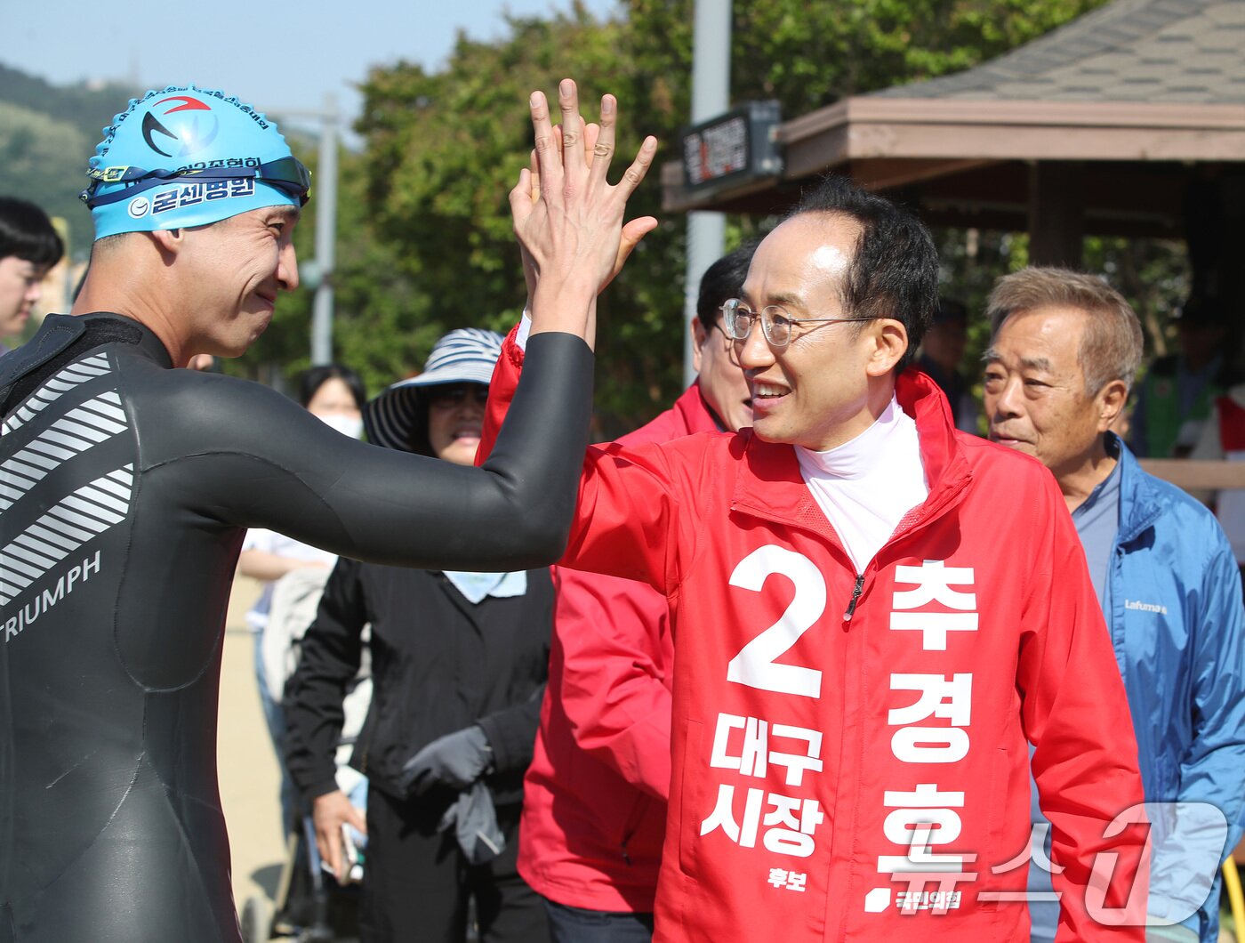 본문 이미지 - 추경호 국민의힘 대구시장 후보가 10일 오전 대구 수성구 수성못에서 열린 제22회 대구시장배 전국 철인3종 경기대회를 찾아 참가자와 가족 등 시민과 인사 나누고 있다. 2026.5.10 ⓒ 뉴스1 공정식 기자