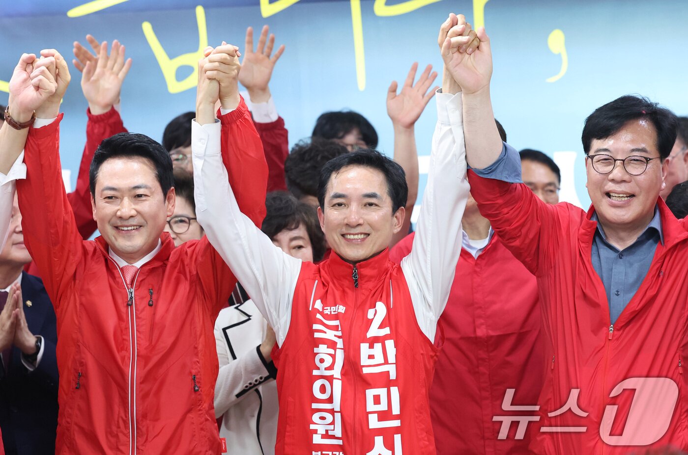 본문 이미지 - 장동혁 국민의힘 대표와 부산 북갑 국회의원 보궐선거에 출마한 박민식 후보가 10일 부산 북구 박 후보 선거사무소에서 열린 선거사무소 개소식에서 참석자들과 손을 맞잡고 있다. 2026.5.10 ⓒ 뉴스1 신웅수 기자