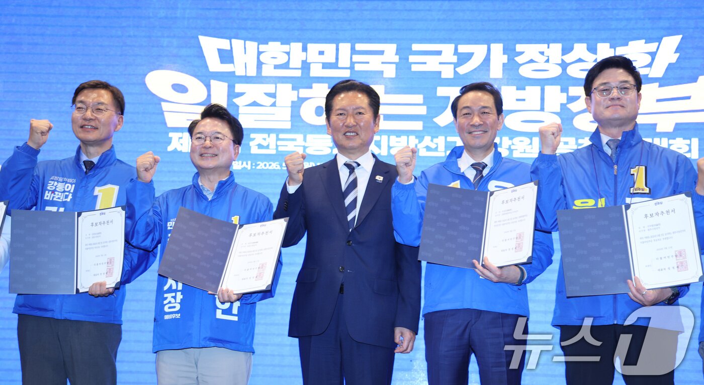 본문 이미지 - 정청래 더불어민주당 대표가 11일 강원 춘천시 스카이컨벤션에서 열린 강원 공천자대회에서 우상호 강원도지사 후보를 비롯한 참석자들에게 공천장을 수여한 후 기념 촬영을 하고 있다. 2026.5.11 ⓒ 뉴스1 신웅수 기자
