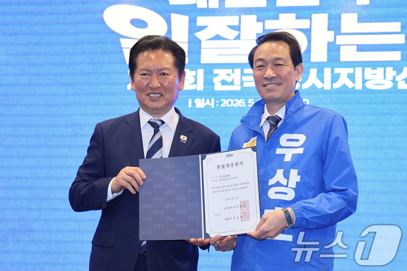 본문 이미지 - 정청래 더불어민주당 대표가 11일 강원 춘천시 스카이컨벤션에서 열린 강원 공천자대회에서 우상호 강원도지사 후보에게 공천장을 수여하고 있다. 2026.5.11 ⓒ 뉴스1 신웅수 기자