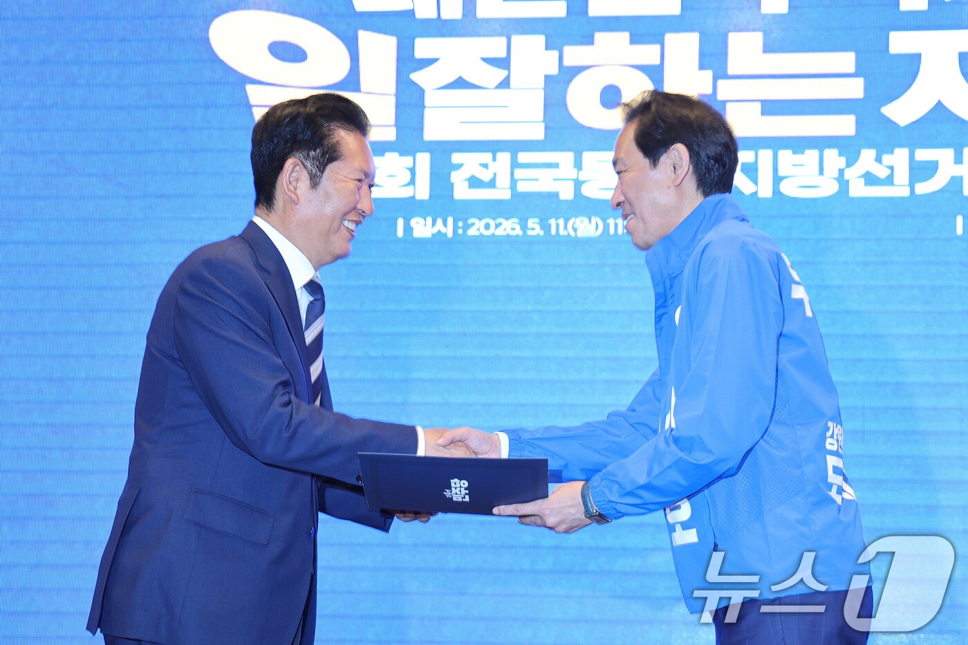 본문 이미지 - 정청래 더불어민주당 대표가 11일 강원 춘천시 스카이컨벤션에서 열린 강원 공천자대회에서 우상호 강원도지사 후보에게 공천장을 수여하고 있다. 2026.5.11 ⓒ 뉴스1 신웅수 기자
