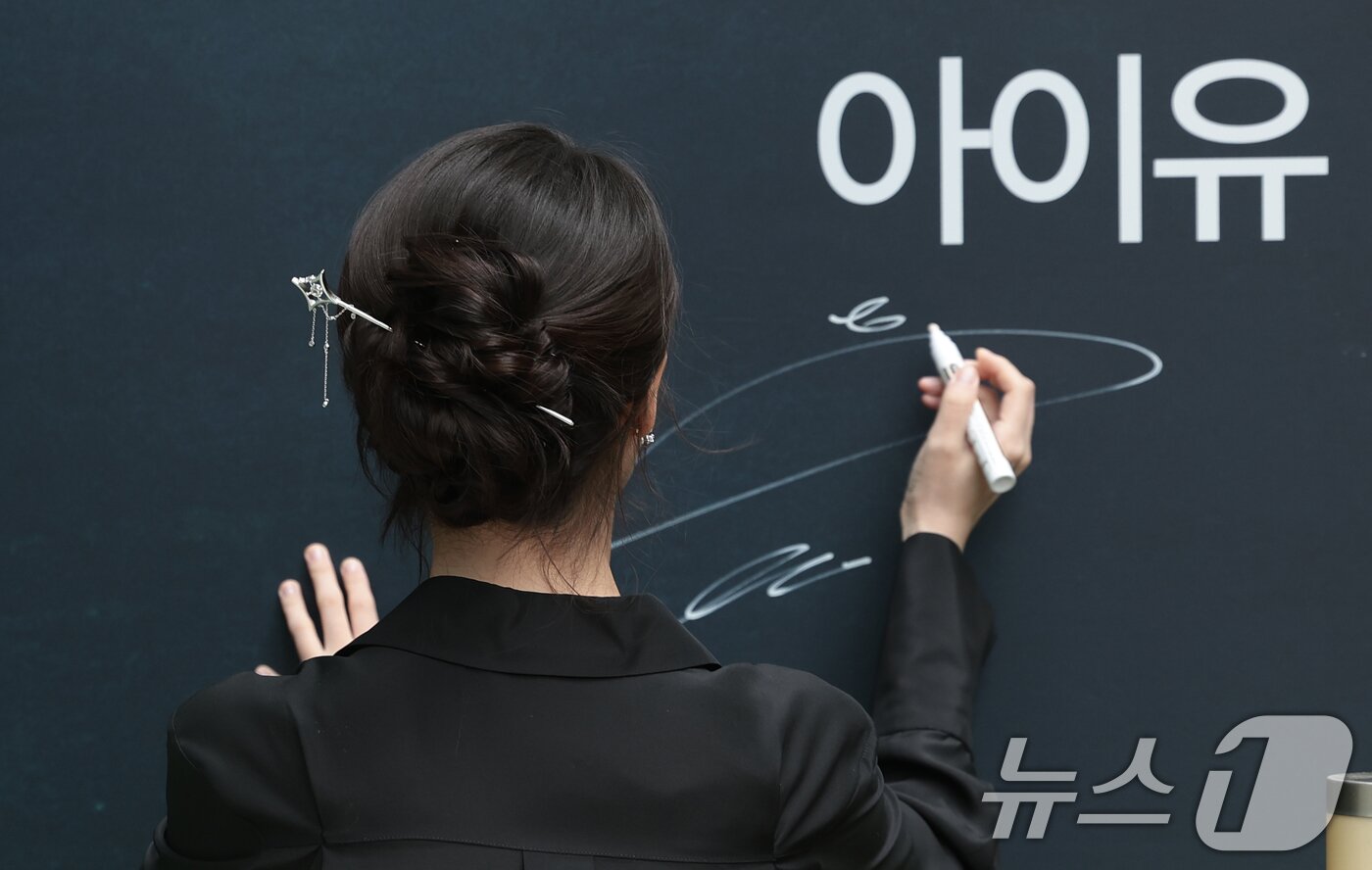 본문 이미지 - 배우 겸 가수 아이유가 11일 서울 송파구 제이에스티나 본사 쇼룸에서 열린 포토콜 행사에 참석해 사인을 하고 있다. ⓒ 뉴스1 권현진 기자