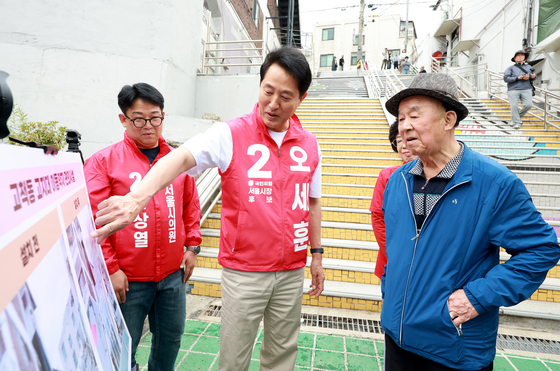 어르신에게 고지대 이동약자 편의시설 설명하는 오세훈 후보