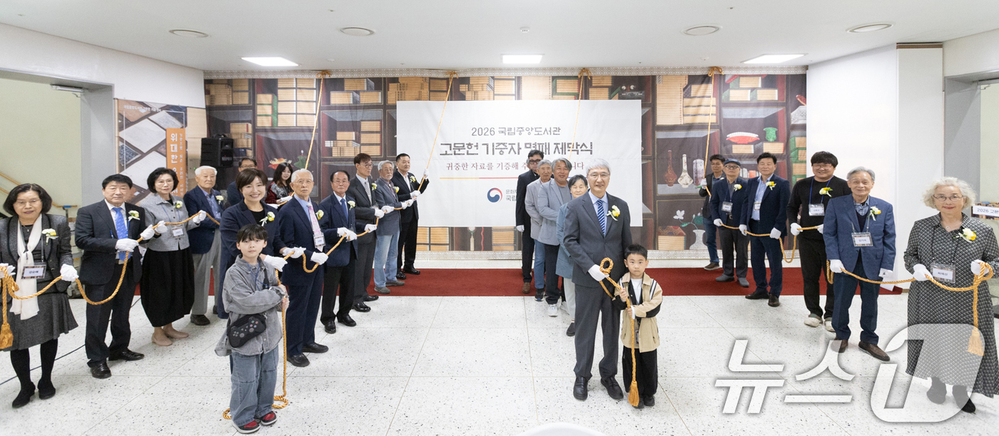(서울=뉴스1) = 김희섭 국립중앙도서관장(앞줄 오른쪽 두번째)과 기증자들이 11일 서울 서초구 국립중앙도서관에서 열린 고문헌 명패제막식에서 현수막 제막에 앞서 기념촬영을 하고 있 …