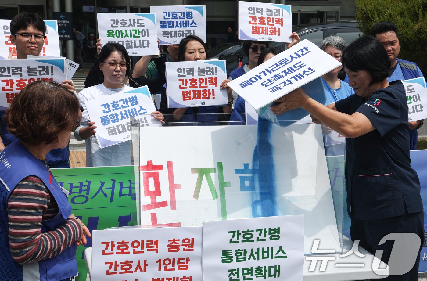 본문 이미지 - 공공운수노조 의료연대본부와 행동하는 간호사회 회원들이 12일 서울 종로구 서울대학교병원 본관 앞에서 열린 '인력 늘려! 환자 지켜! 5.12 국제 간호사의 날 기자회견'에서 모래를 부어 환자 행복을 위하는 상징 의식을 하고 있다. 2026.5.12 ⓒ 뉴스1 임지훈 인턴기자